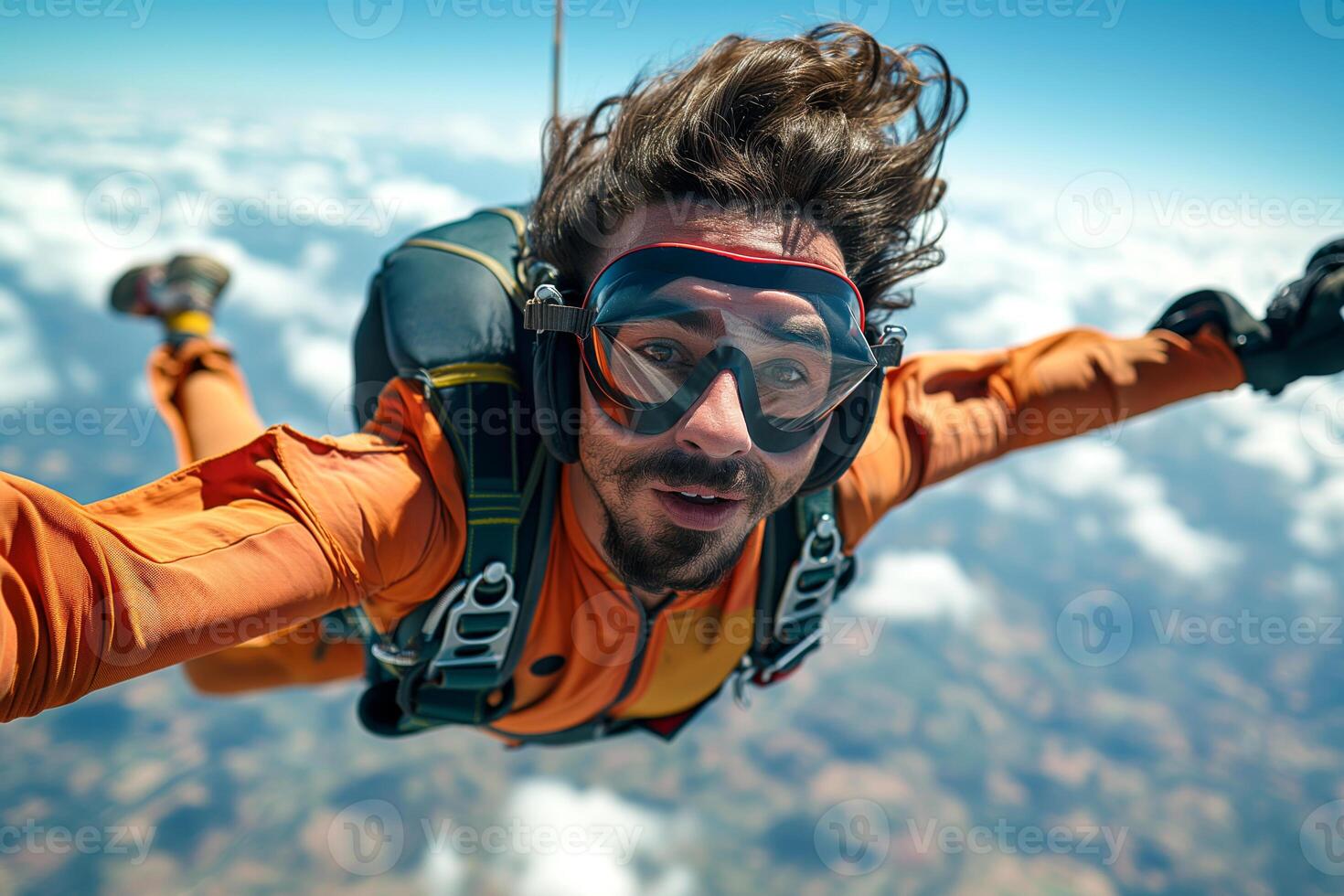 A male skydiver in an orange jumpsuit captures his thrilling leap against a backdrop of clouds. photo