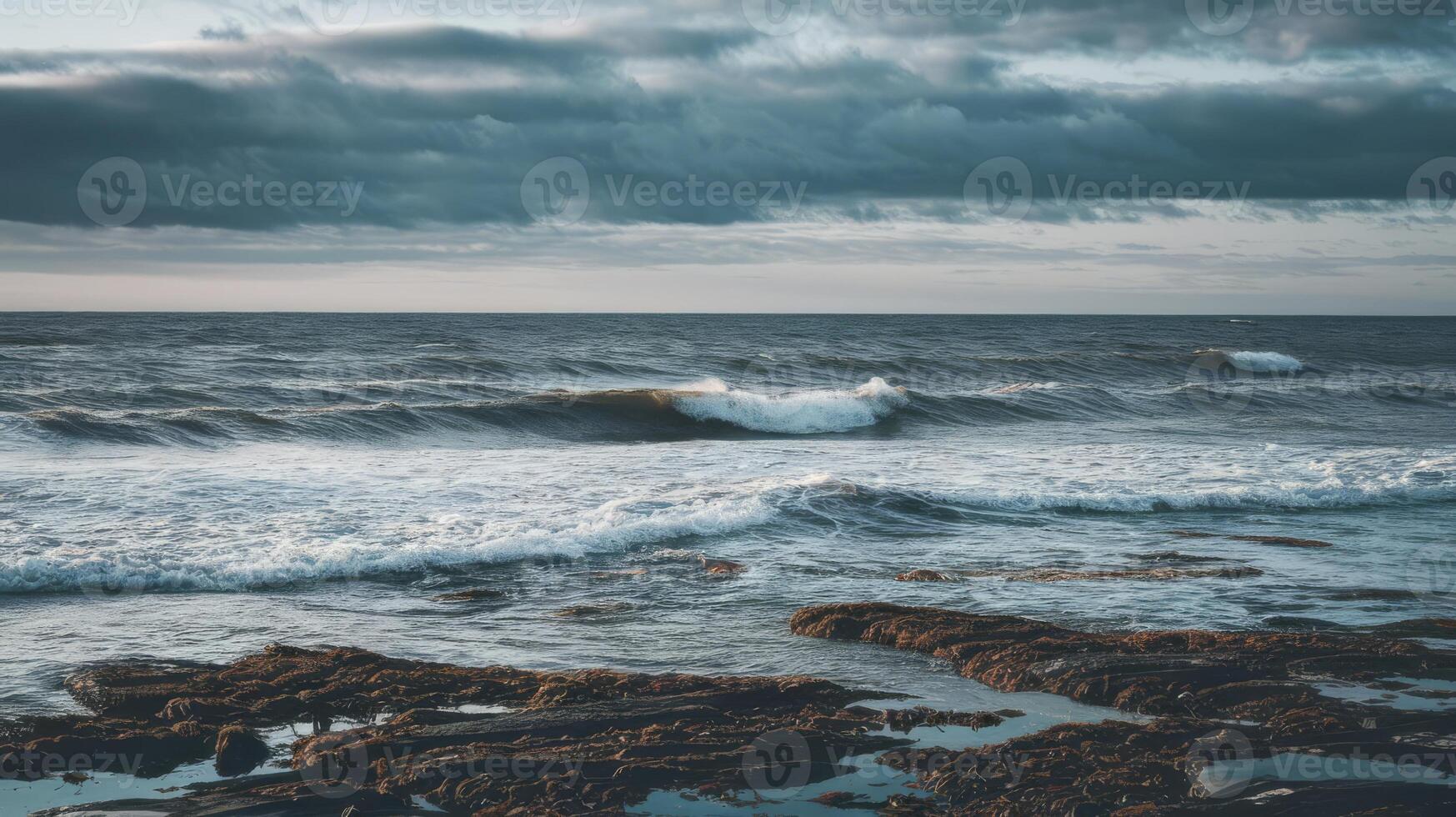 A view of the ocean with waves crashing on rocks photo