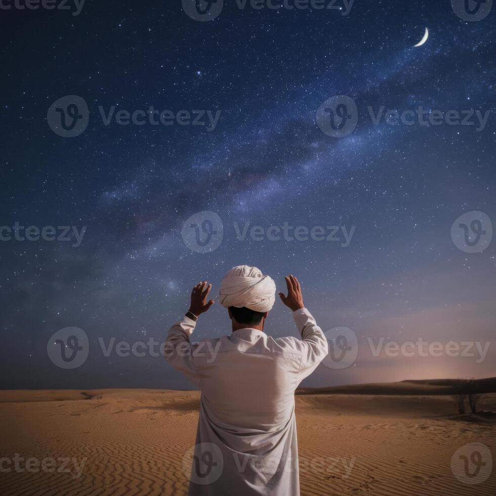 Man praying in the desert at night with the milky and crescent photo