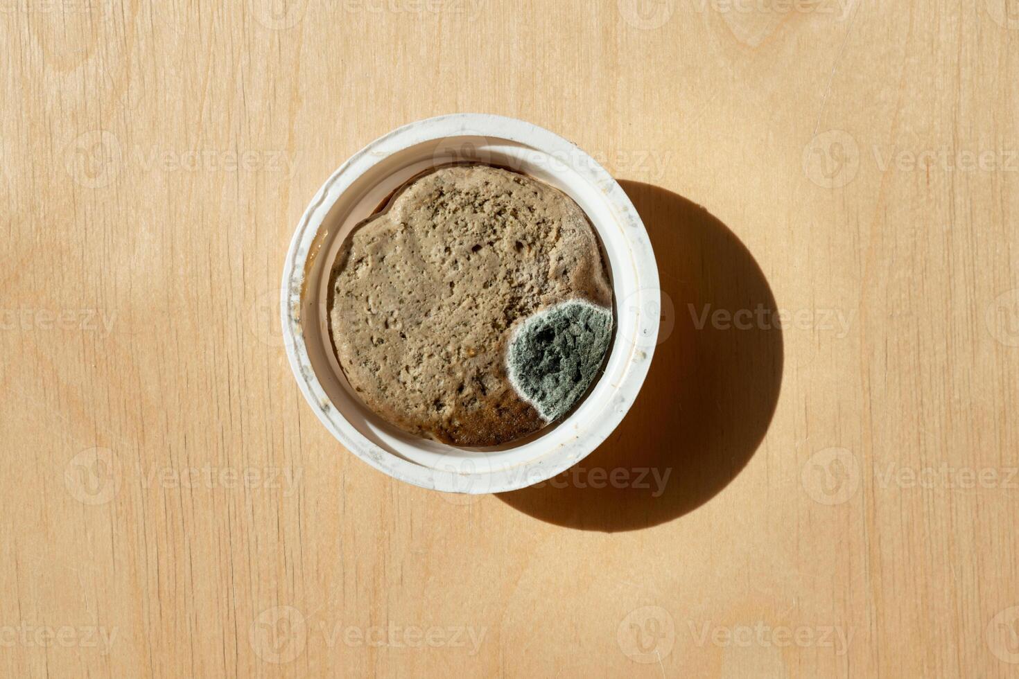 deteriorated meat pate with fungus and mold growth inside its packaging. Food safety, waste, and contamination concept photo