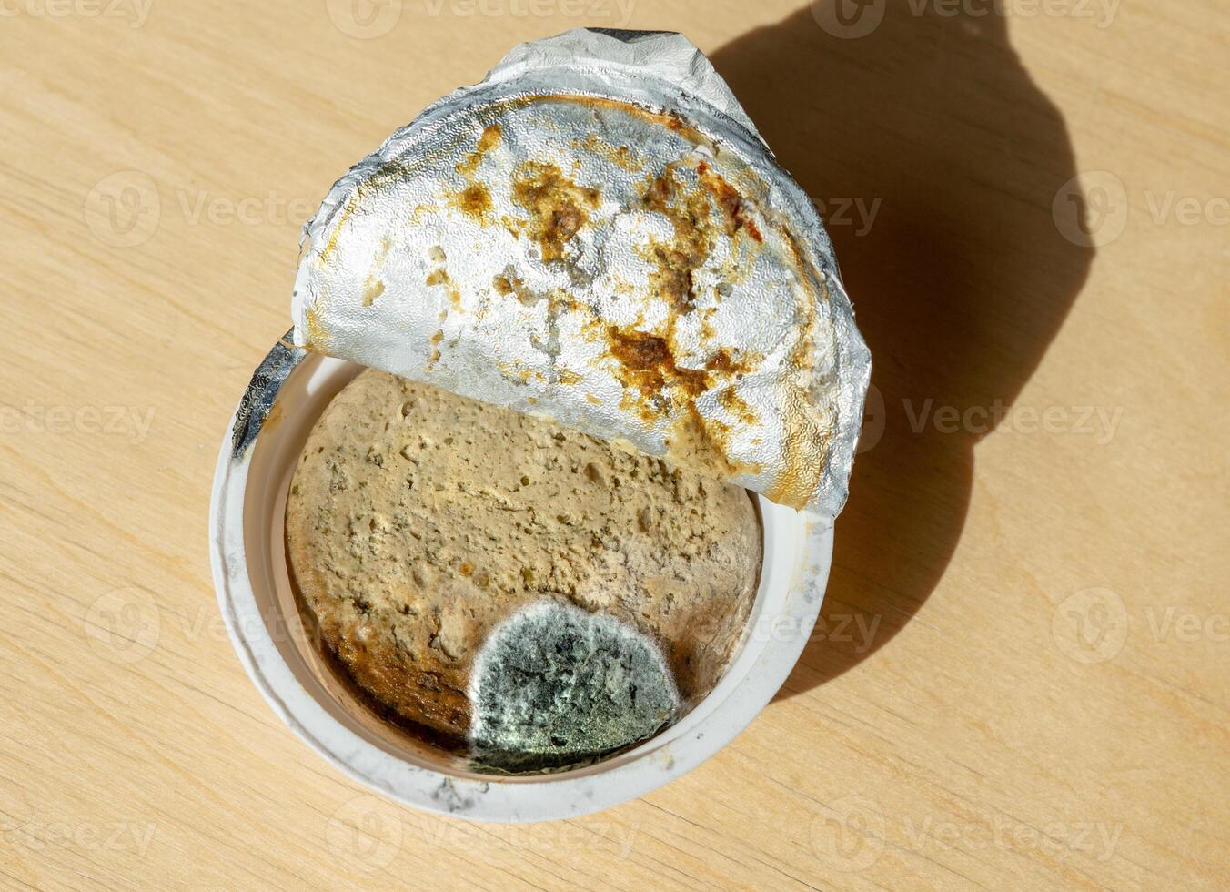 Close-up of spoiled pate with visible mold inside an opened plastic container. Food spoilage, expiration, and contamination concept, with bacterial growth and mold spots photo