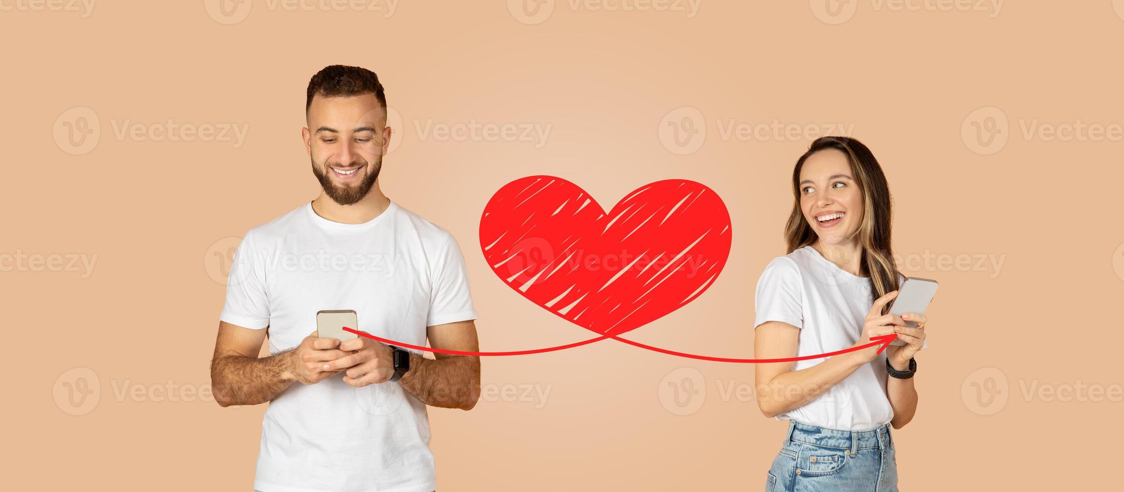 A couple shares a joyful moment as they send messages to each other on their smartphones, celebrating their love during St. Valentine's Day. The heart connection symbolizes their affection. photo