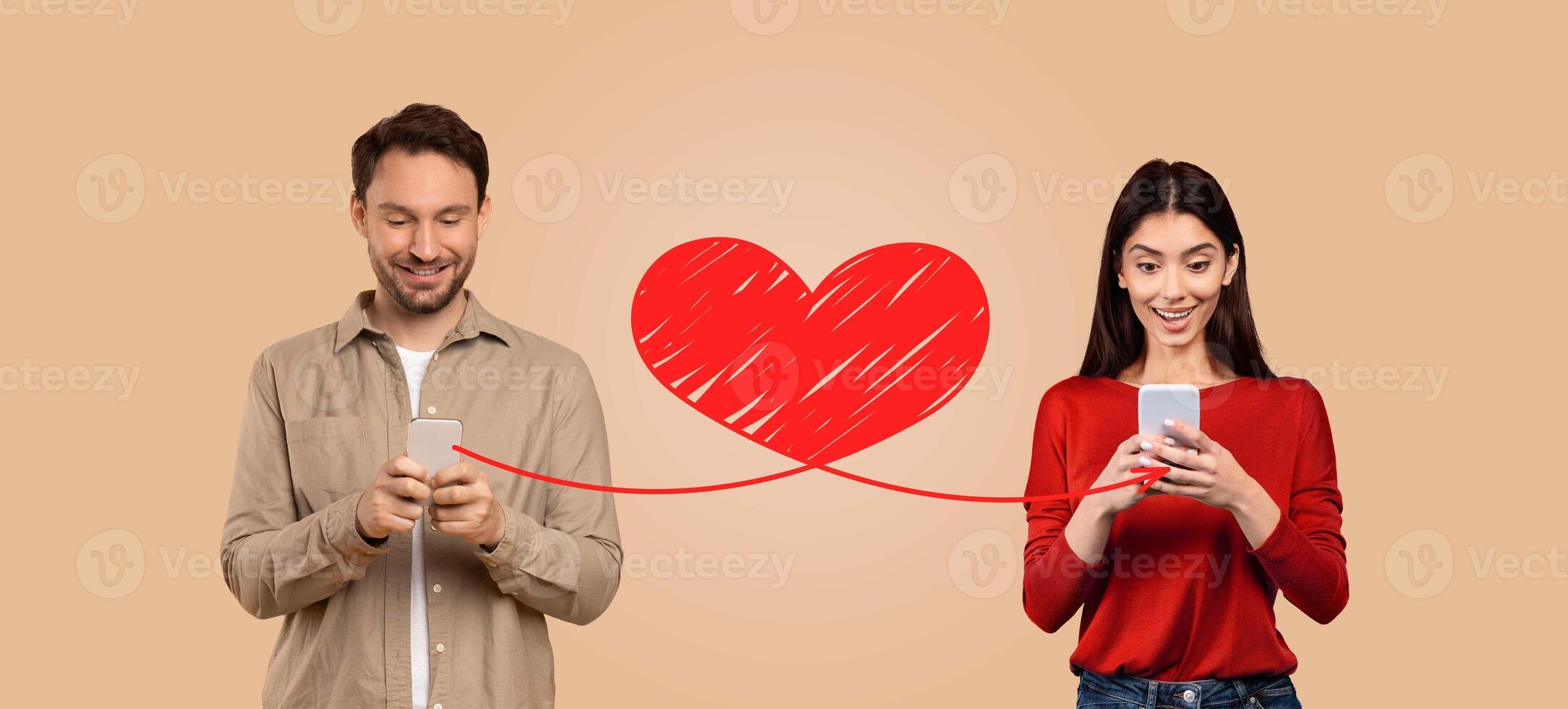 A couple expresses their affection on Valentine's Day, each using their smartphone to send messages. They smile while engaging with an online application, celebrating their bond. photo