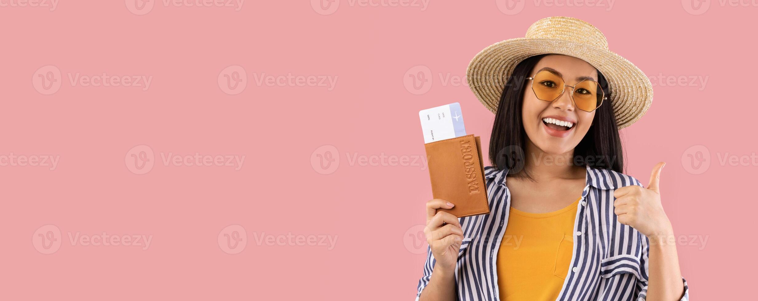 Time For Vacation. Excited Asian Woman With Passport And Tickets Showing Thumb Up Gesture, Ready For Summer Trip, Wearing Straw Hat And Glasses, Isolated On Pink Studio Background, Banner photo