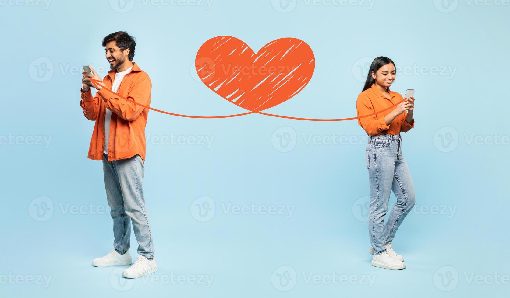 A happy couple celebrates St. Valentine's Day while using their smartphones to send loving messages. They express affection in a playful and modern way, embodying love and connection. photo