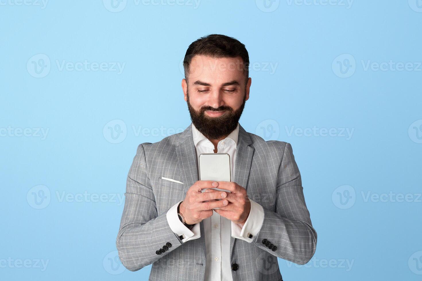 Handsome bearded entrepreneur searching web for business data over blue background photo