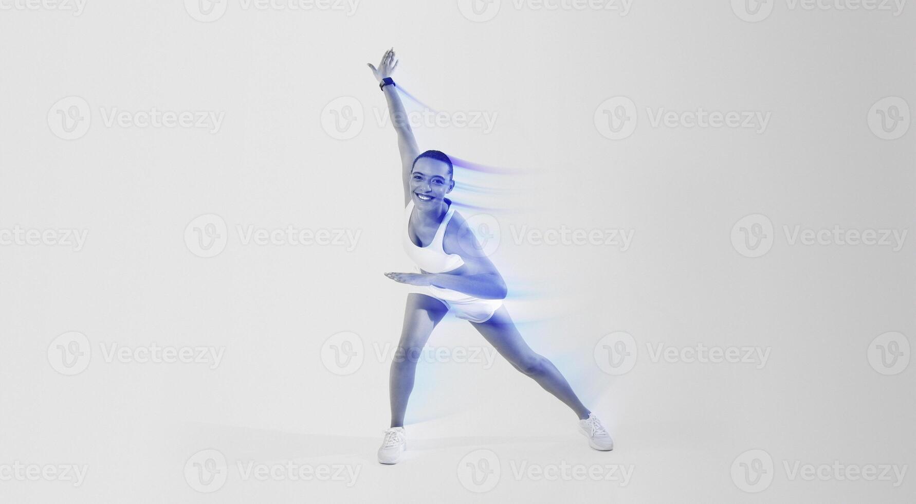 A joyful woman with a shaved head in a dynamic yoga pose, wearing a white sports outfit and sneakers, smiles widely on a gradient pink and yellow background, expressing energy and happiness photo