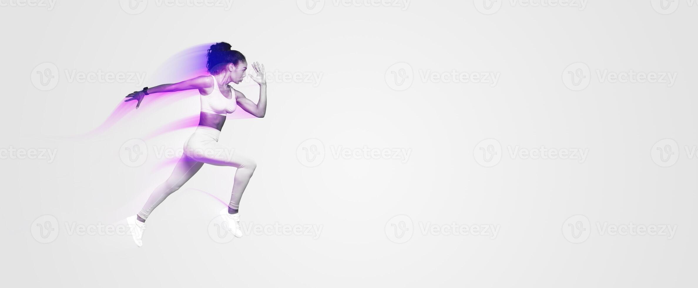 Athletic young African American woman in yellow activewear leaping during dynamic workout on blue studio backdrop, epitome of strength and beauty of fitness. Full length, side view photo