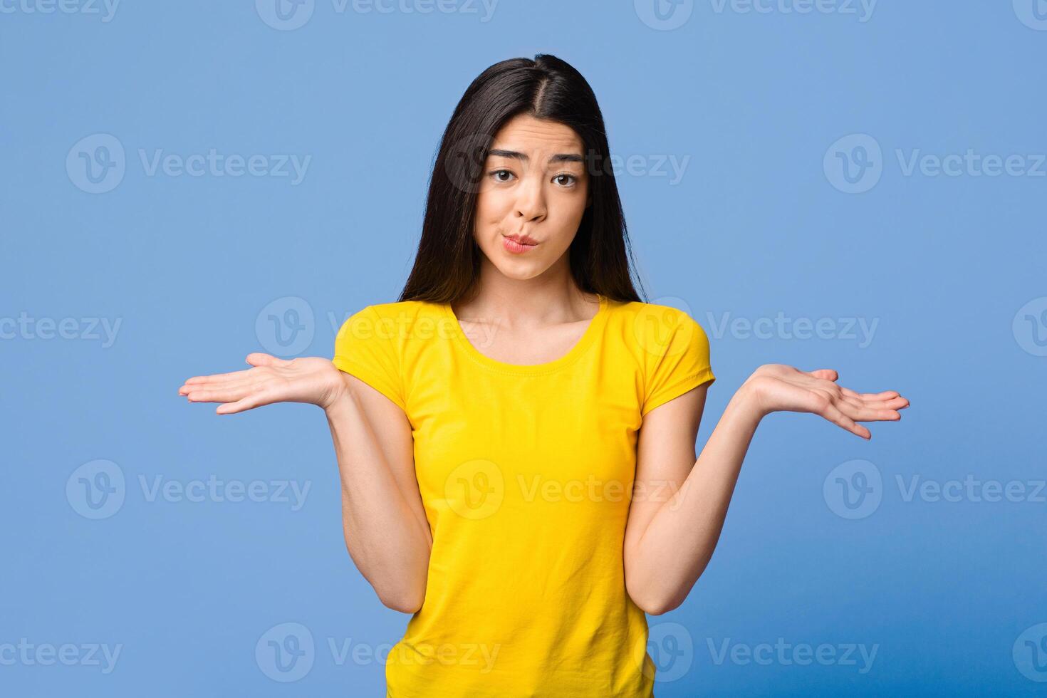 I Don't Know. Careless Asian Girl Shrugging Shoulders Over Purple Studio Background, Copy Space photo