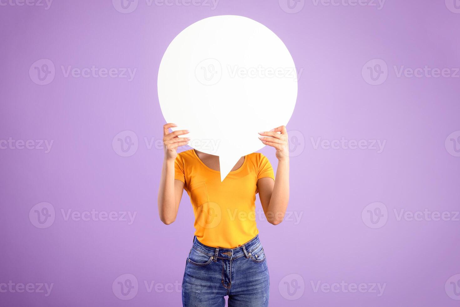 Information, Thought, Quote And Opinion Concept. Young woman hiding her face behind blank white speech bubble, isolated on purple studio background. Empty space for text or feedback on balloon circle photo