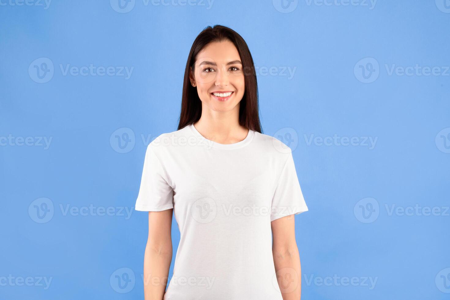Portrait of beautiful casual smiling caucasian girl posing and looking at camera isolated over turquoise studio wall photo