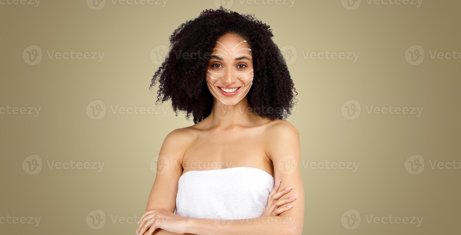 African American woman enjoys a relaxing skin care treatment focusing on face massage for anti-aging and rejuvenation, wrapped in a towel and smiling in a peaceful indoor space. photo