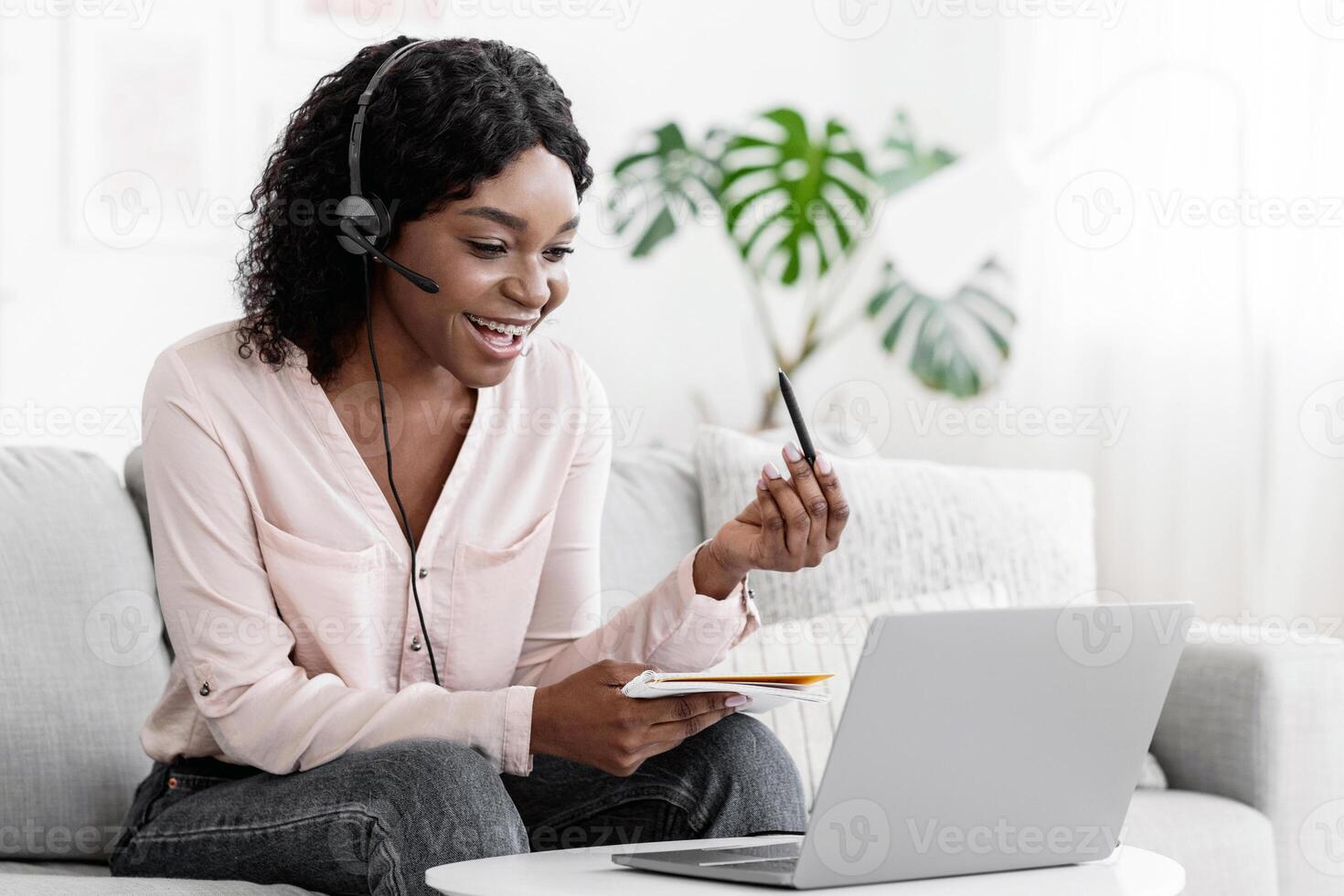 Cheerful Black Female Online Tutor Explaining Subject To Student Via Call, Using Laptop And Headset photo