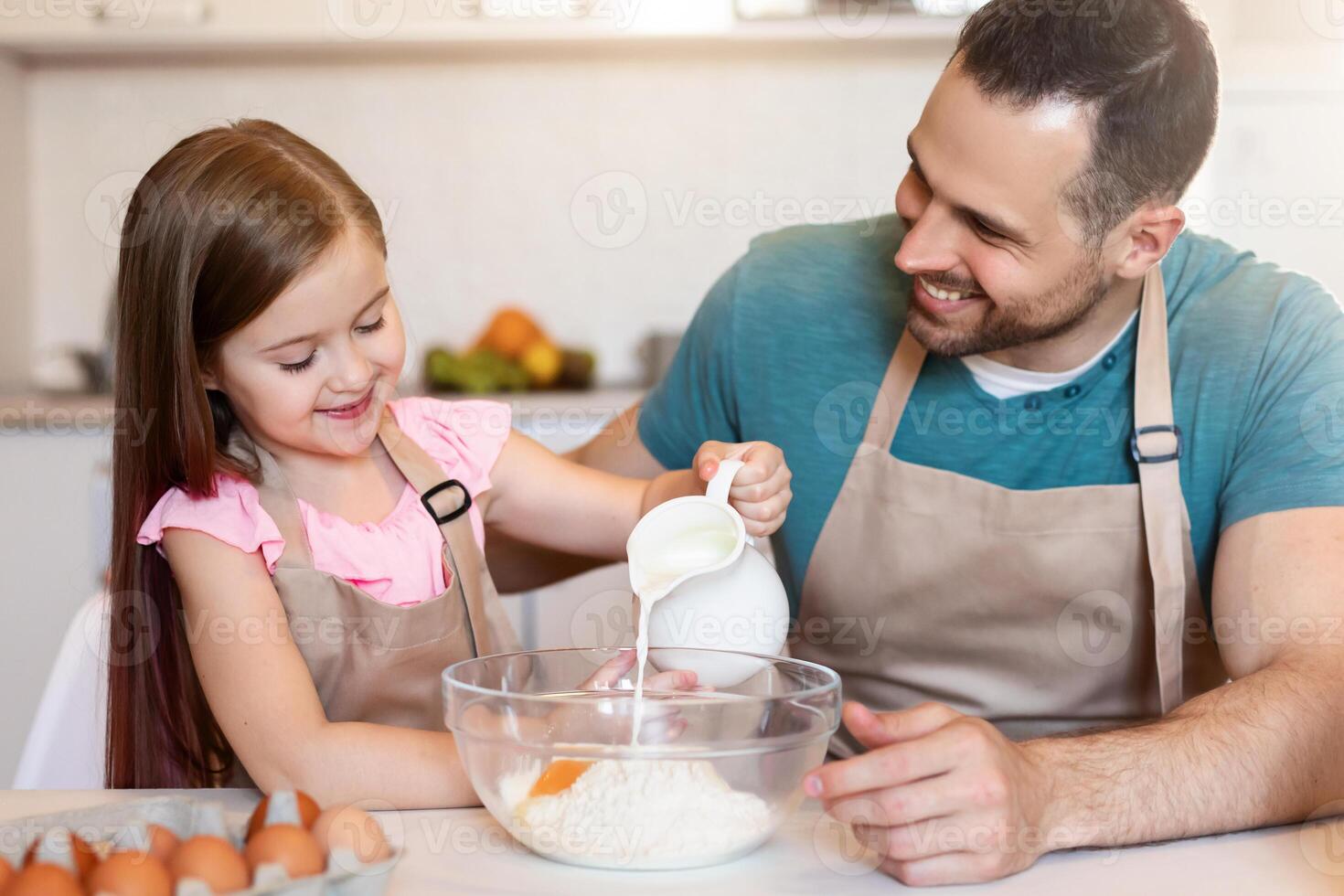 Happy Daddy And Little Daughter Making Dough Baking Cake For Father's Day Enjoying Cooking Together In Modern Kitchen At Home. Family Making Cookies And Pastry On Weekend photo