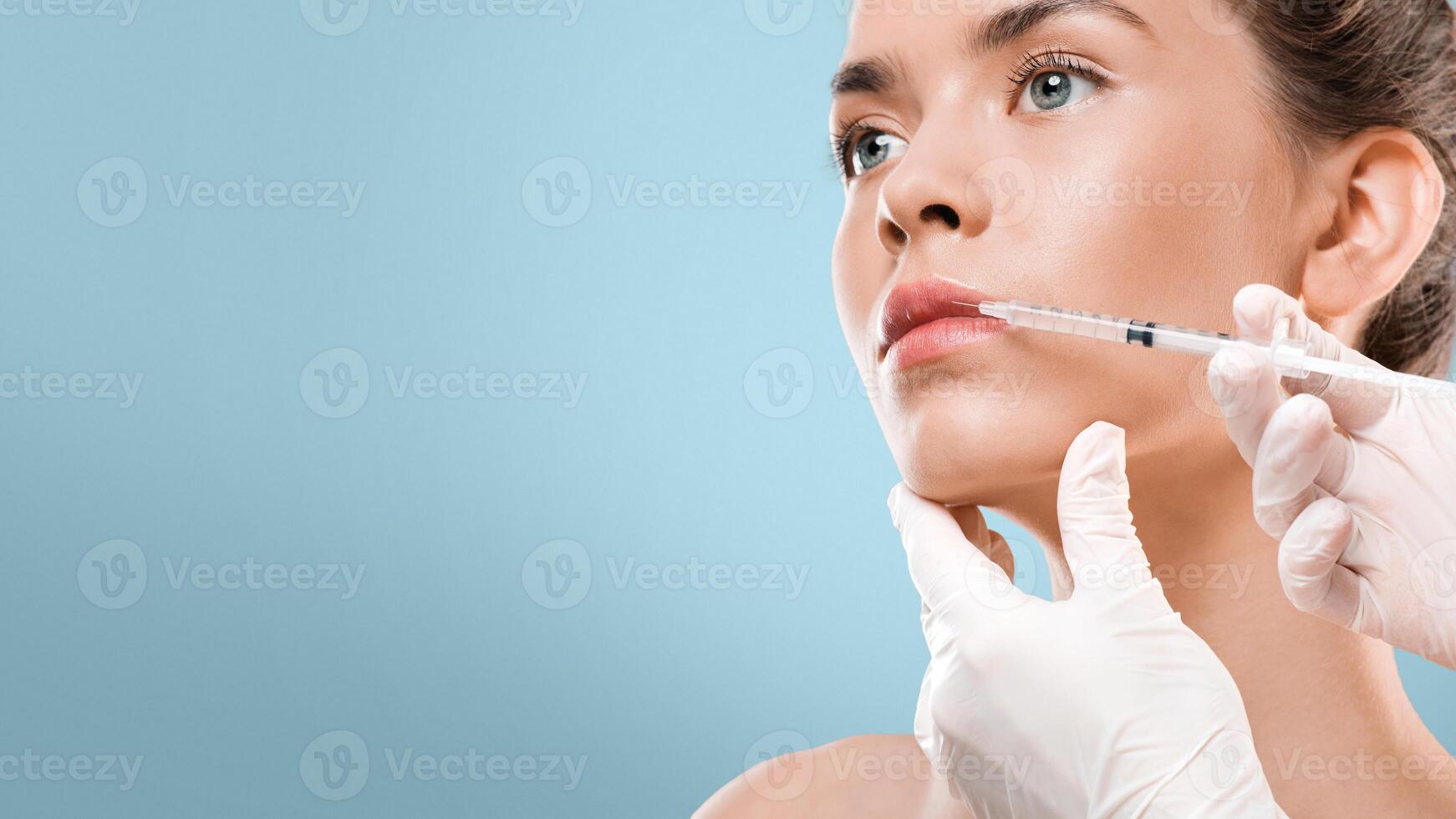 Lip injection for young woman over grey studio background, copy space, closeup photo