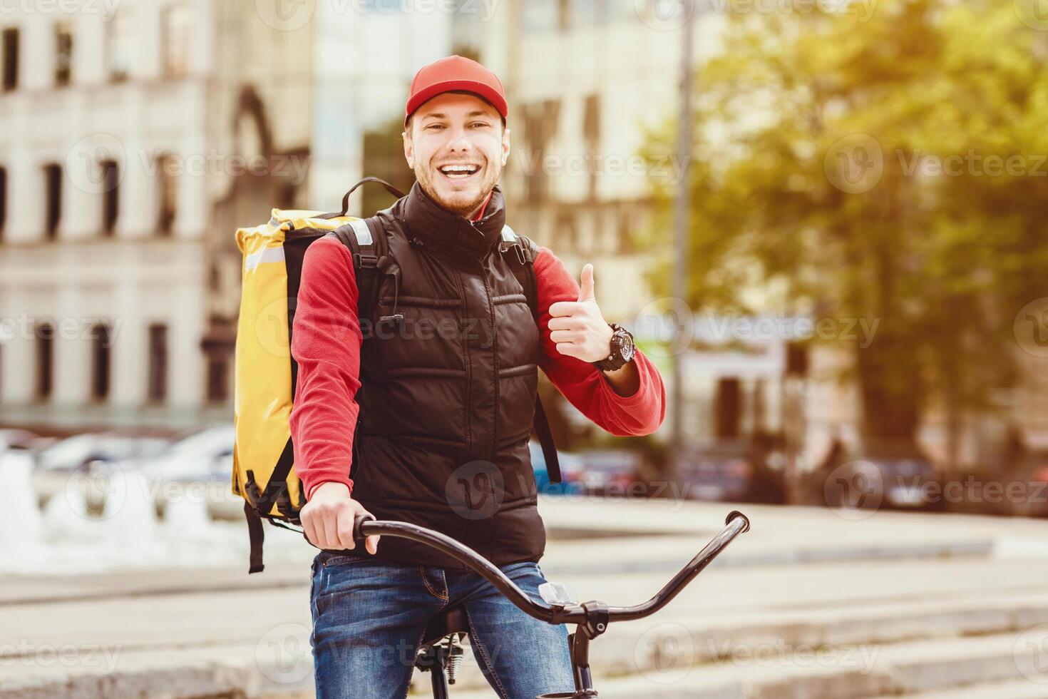 Food Delivery Service. Courier Gesturing Thumbs Up Standing With Delivering Backpack And Bike In City Outdoor. Free Space photo