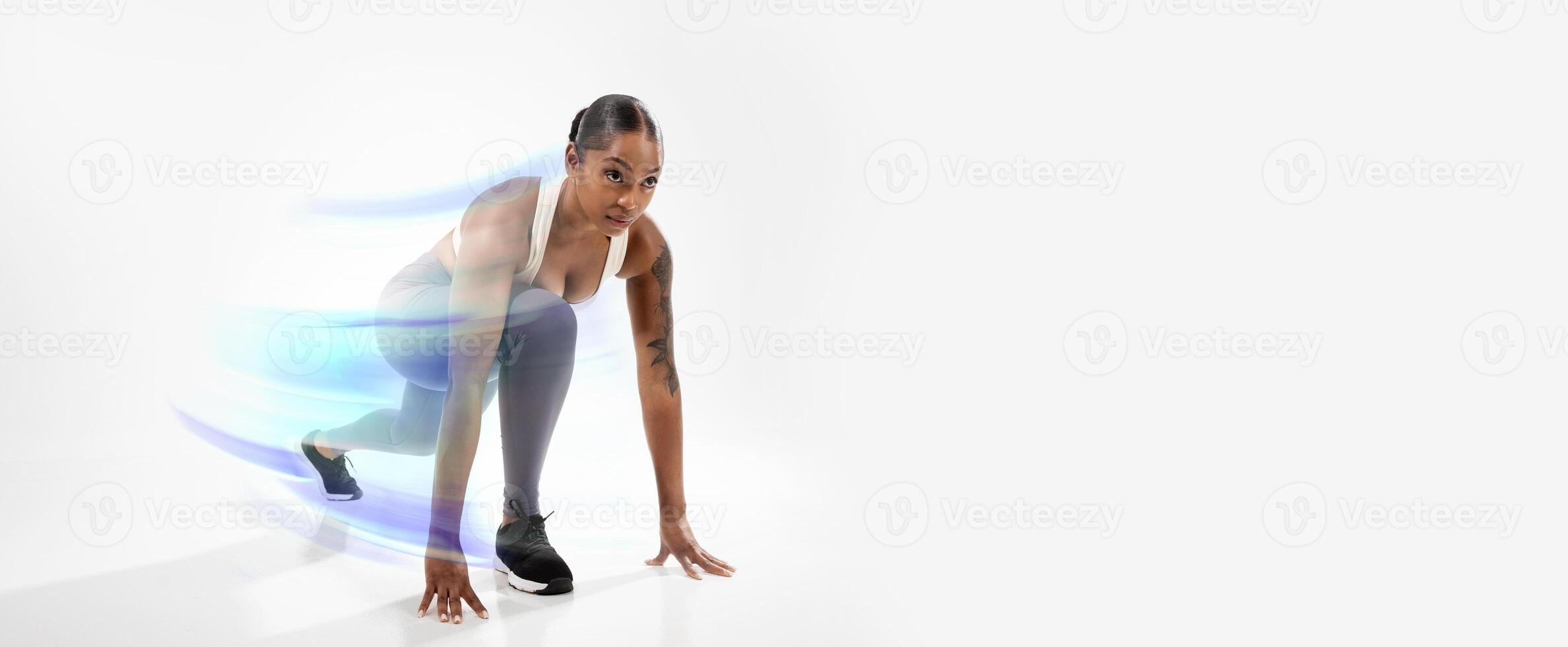 Motivated Sporty African American Lady Doing Crouch Start Ready For Running Race Over White Background In Studio, Wearing Fitwear. Woman Runner Preparing For Marathon. Sport Motivation photo