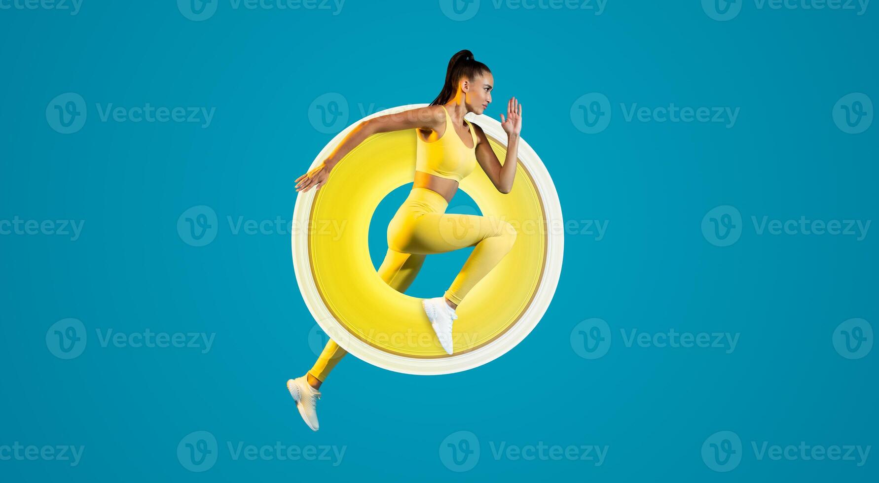Side View Of Sportswoman Jumping In Mid Air Posing Looking Aside Exercising Over Blue Studio Background. Fitness Lady Running In Air. Sport Motivation. Full Length Shot photo