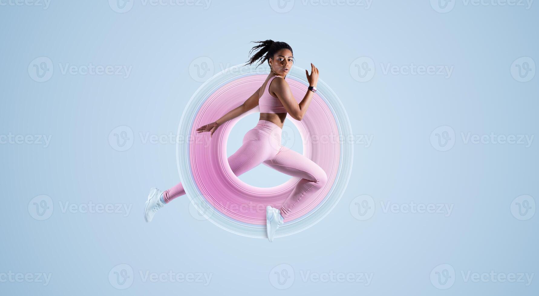 Training concept. Fit African American woman in sportswear jumping or running, exercising on neon blue studio background, free space, full length. Energy and sport photo