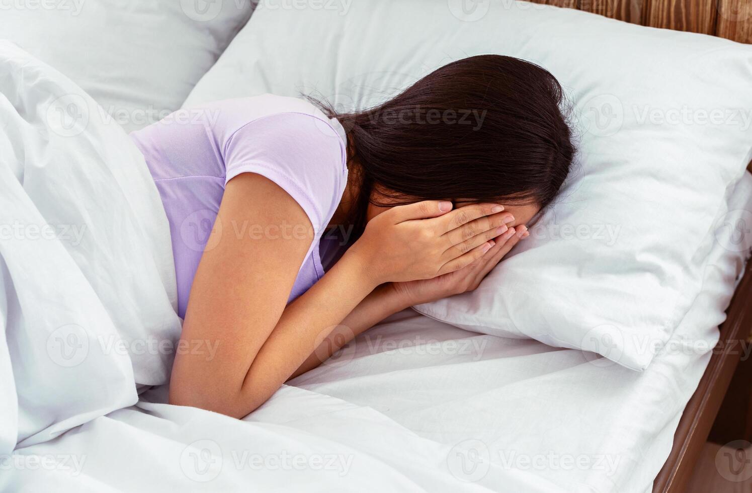 Depression. Unrecognizable Asian Girl Crying Covering Face With Hands Having Mental Health Problems Lying In Bed At Home photo