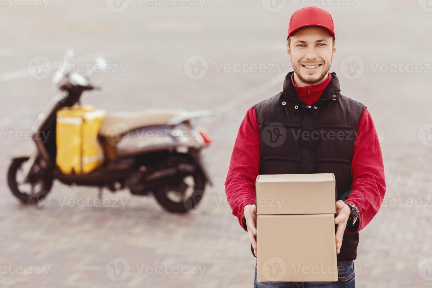 Parcel Delivery. Cheerful Courier Holding Boxes Smiling To Camera Standing Near Motorbike In City. Empty Space For Text photo