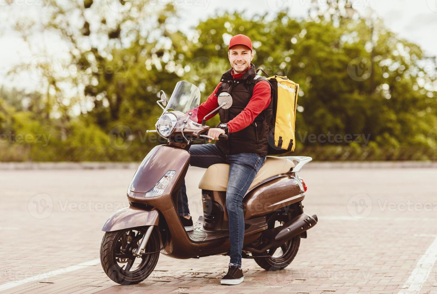 Food Delivery Concept. Courier Guy Sitting On Scooter Delivering Restaurant Meals Outdoor, Smiling To Camera. photo