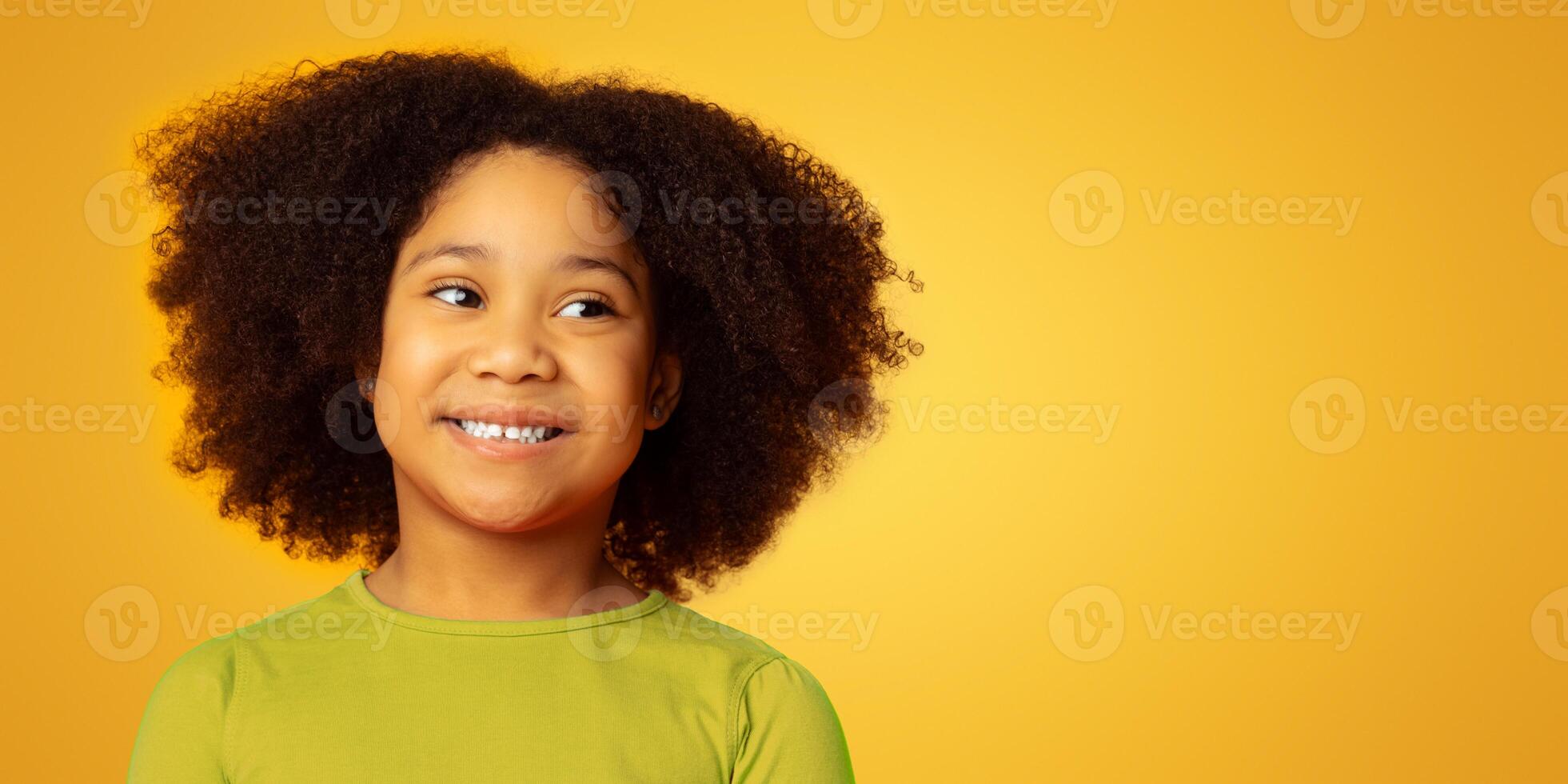 Portrait of lovely african american kid, little girl smiling over yellow background, panorama with free space photo