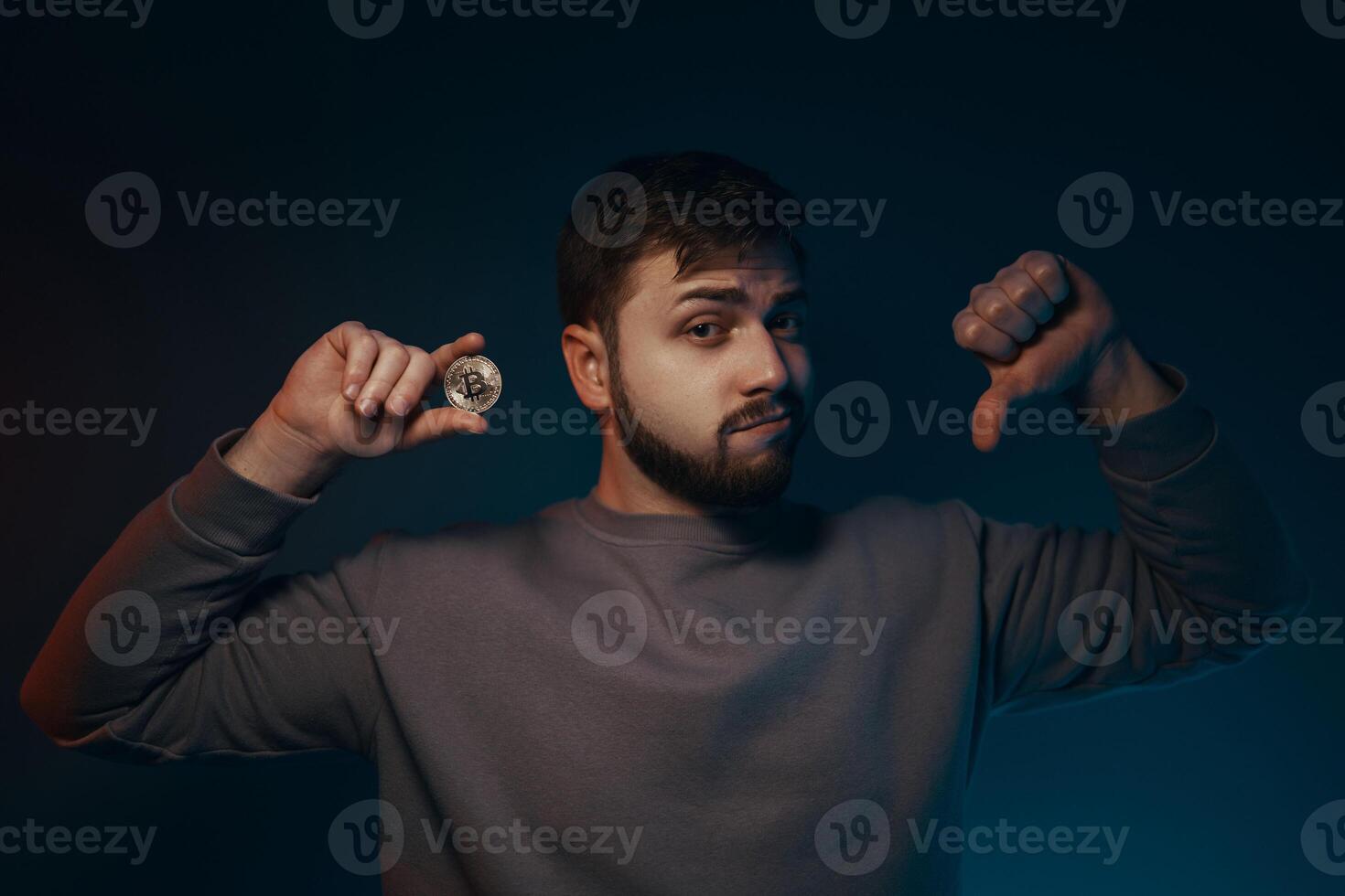 Bitcoin is a scam. Man shows finger down. photo