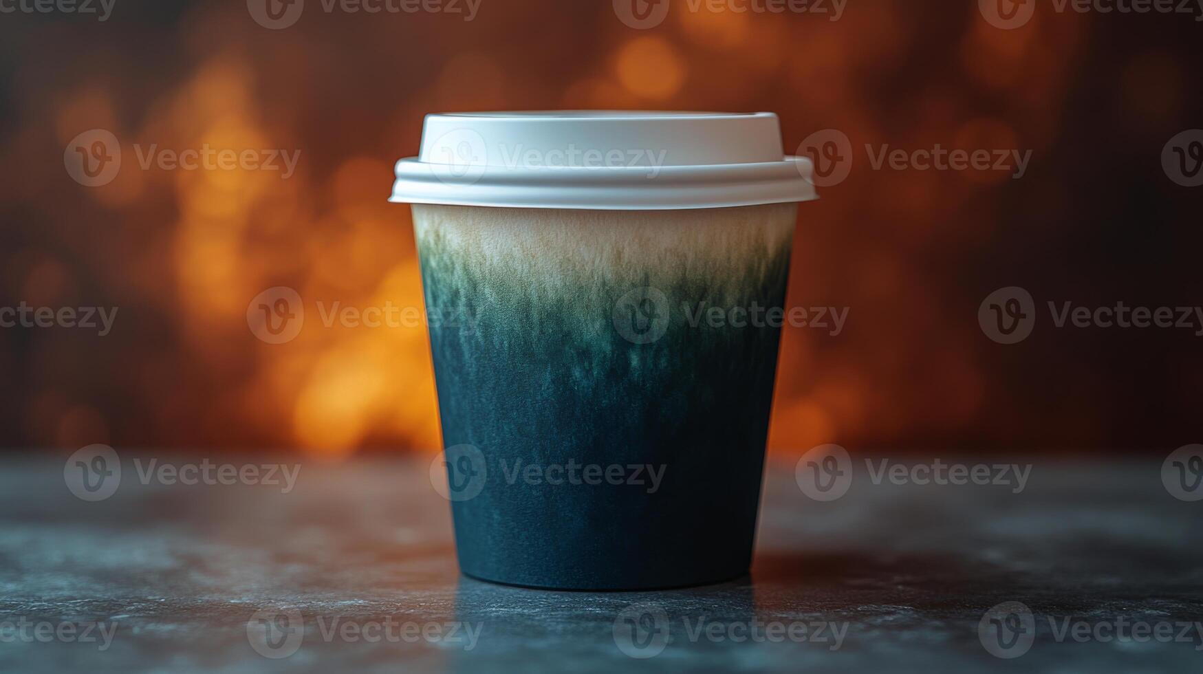 A takeout cup features an appealing gradient that transitions from dark to light colors. The warm backdrop suggests a cozy atmosphere, perfect for enjoying a drink. photo