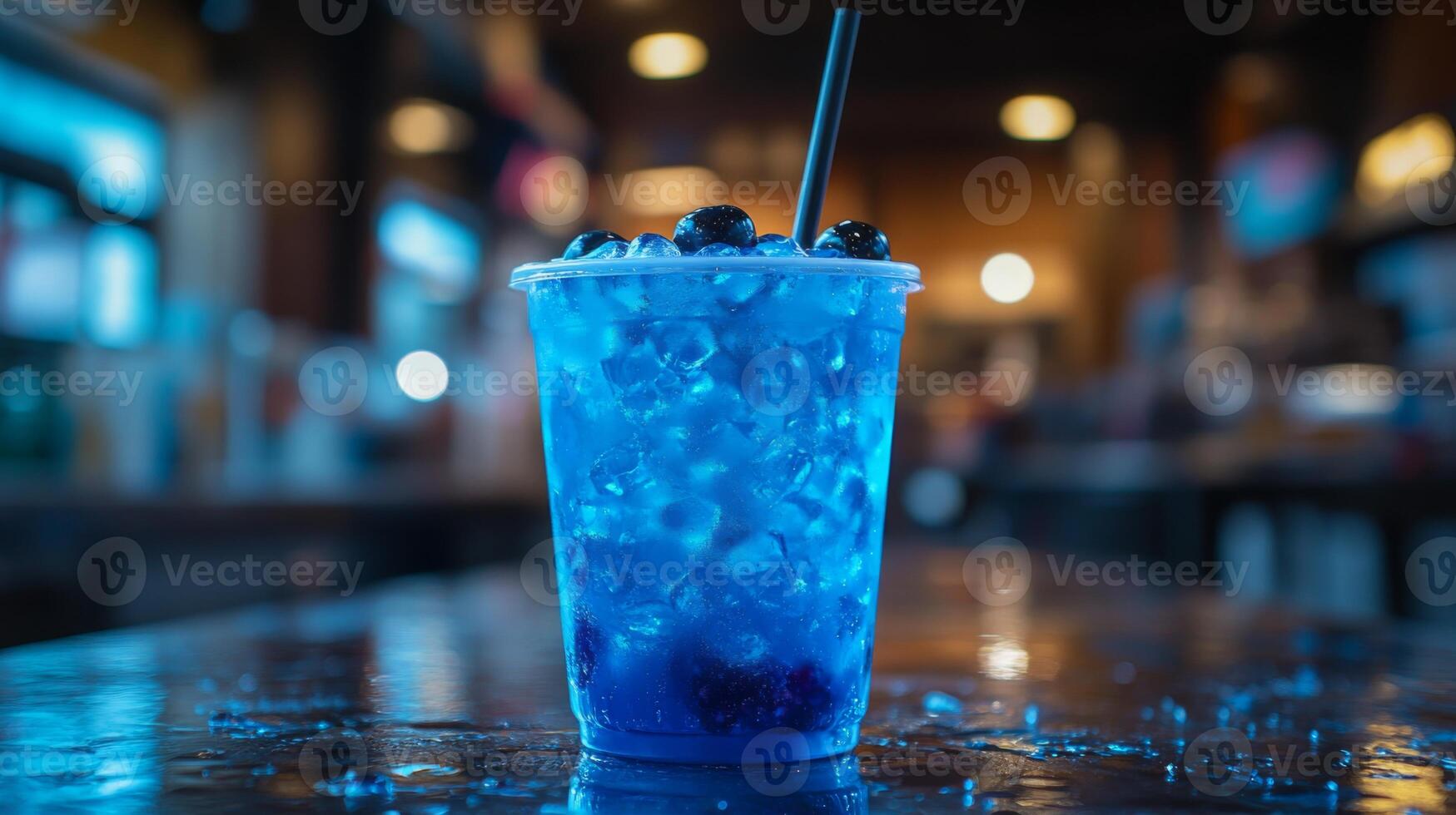 A vibrant blue drink filled with ice and fresh blueberries sits on a wooden table. The ambiance suggests a bustling evening atmosphere with soft lighting in the background. photo