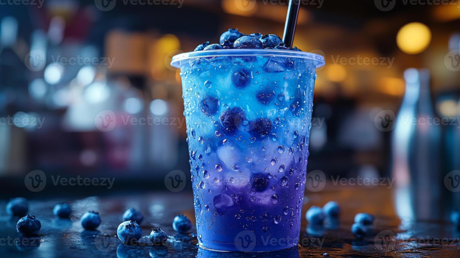 A vibrant blueberry drink with ice and blueberries is placed on a bar counter. The dimly lit background enhances the colorful layers of the beverage, creating an inviting atmosphere. photo