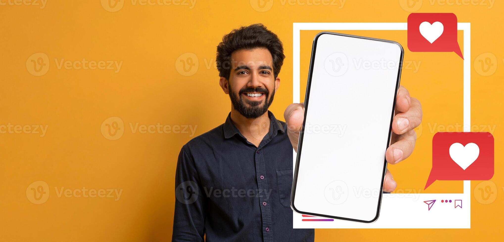 An influencer smiles while holding a smartphone in front of a vibrant orange background. The screen is blank, inviting interaction, with social media icons indicating likes and messages. photo