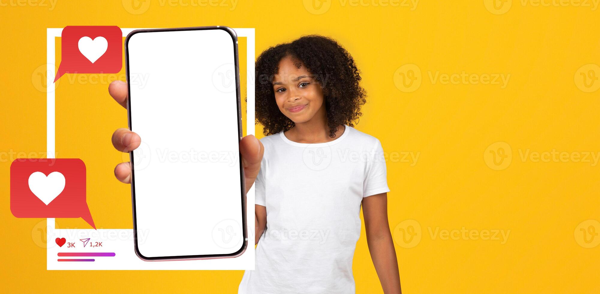 A young influencer poses with a smartphone in hand, displaying a blank screen. The vibrant yellow background enhances the lively mood, emphasizing connection and interaction online. photo