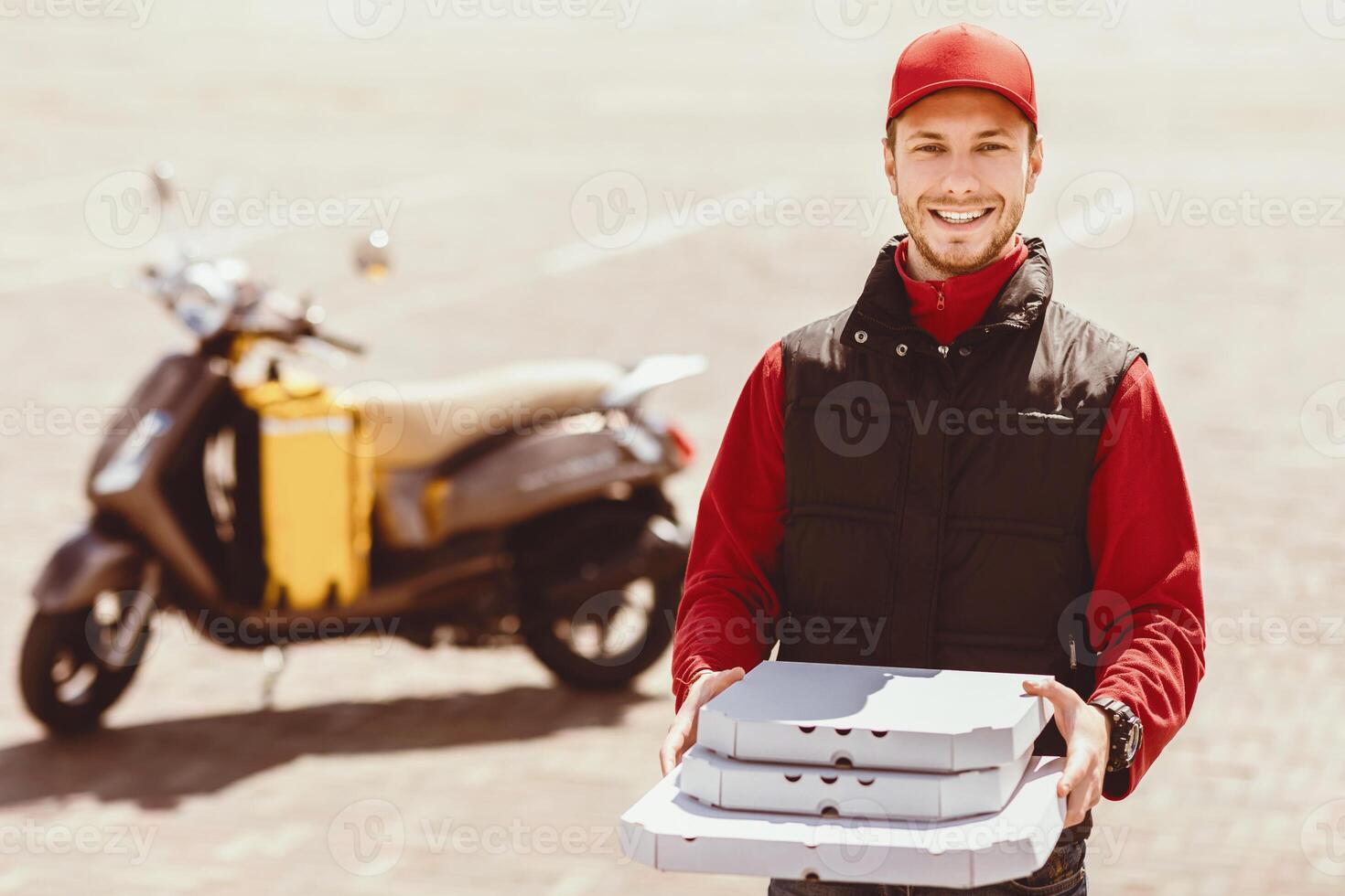 Smiling Courier Man Offering Pizza Boxes To Camera Posing Standing Near Motorbike Outside. Food Delivery. Free Space photo