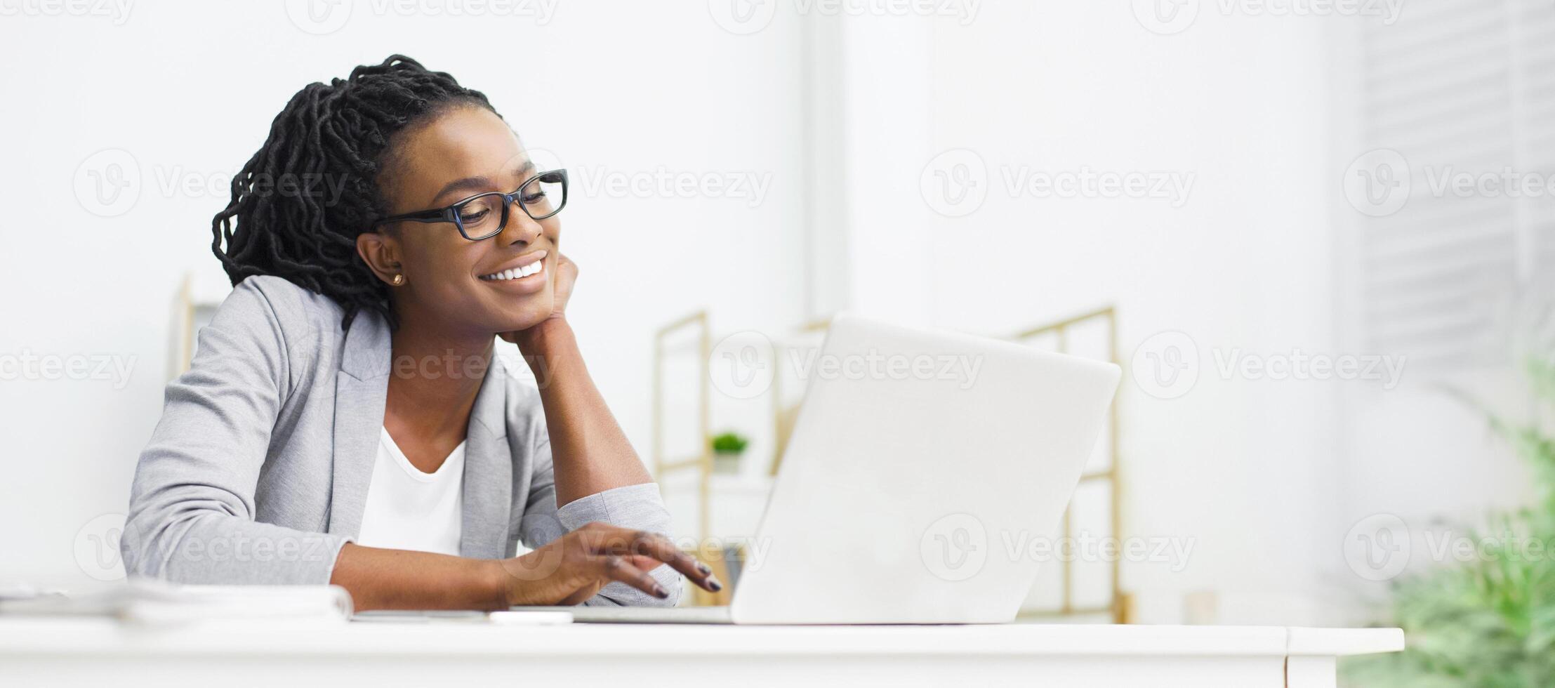 African American Woman Looking At Laptop Screen And Smiling, Working On New Project In Office, Panorama, Copy Space photo