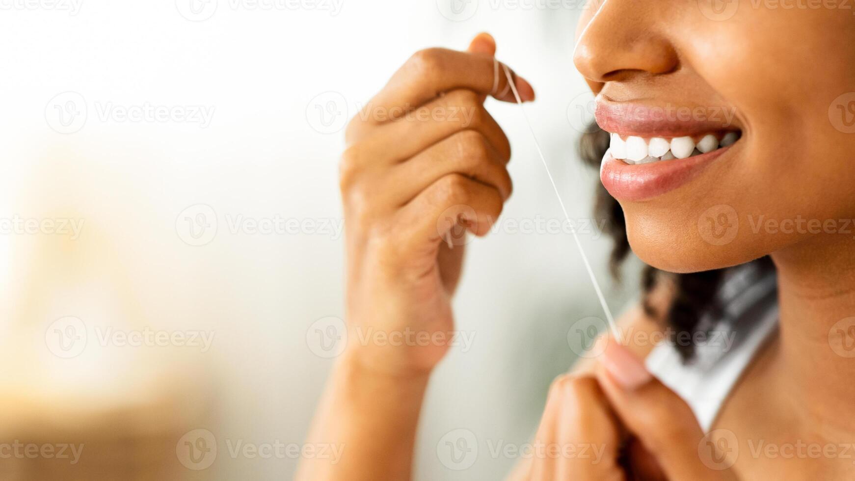 Tooth Care Routine. Smiling Black Woman With Perfect Teeth Using Dental Floss At Home, Cropped Image With Copy Space, Closeup photo