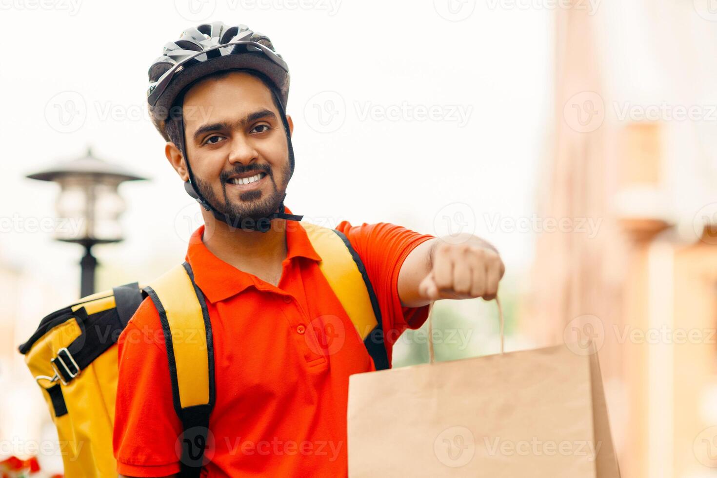 Courier with bicycle delivering packages in city. Online order by courier with yellow backpack on bicycle at street, close up, copy space photo