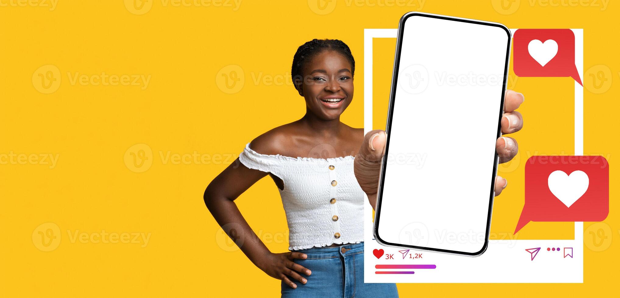 A cheerful influencer smiles while holding a blank smartphone against a vibrant yellow background. The device displays engaging social media icons, suggesting interaction and communication online. photo