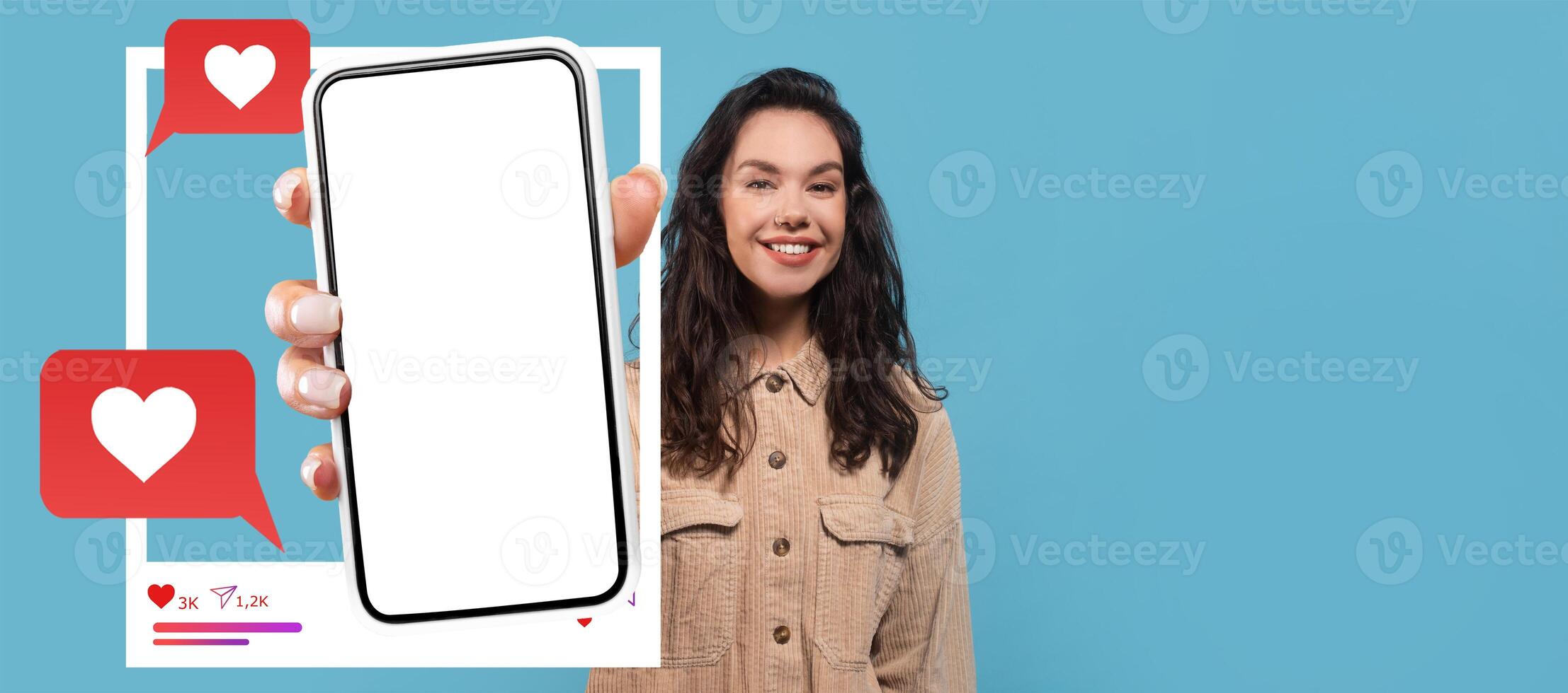 An influencer enthusiastically displays a smartphone against a bright blue background. Heart icons and chat bubbles suggest the excitement of online interactions and social networking. photo