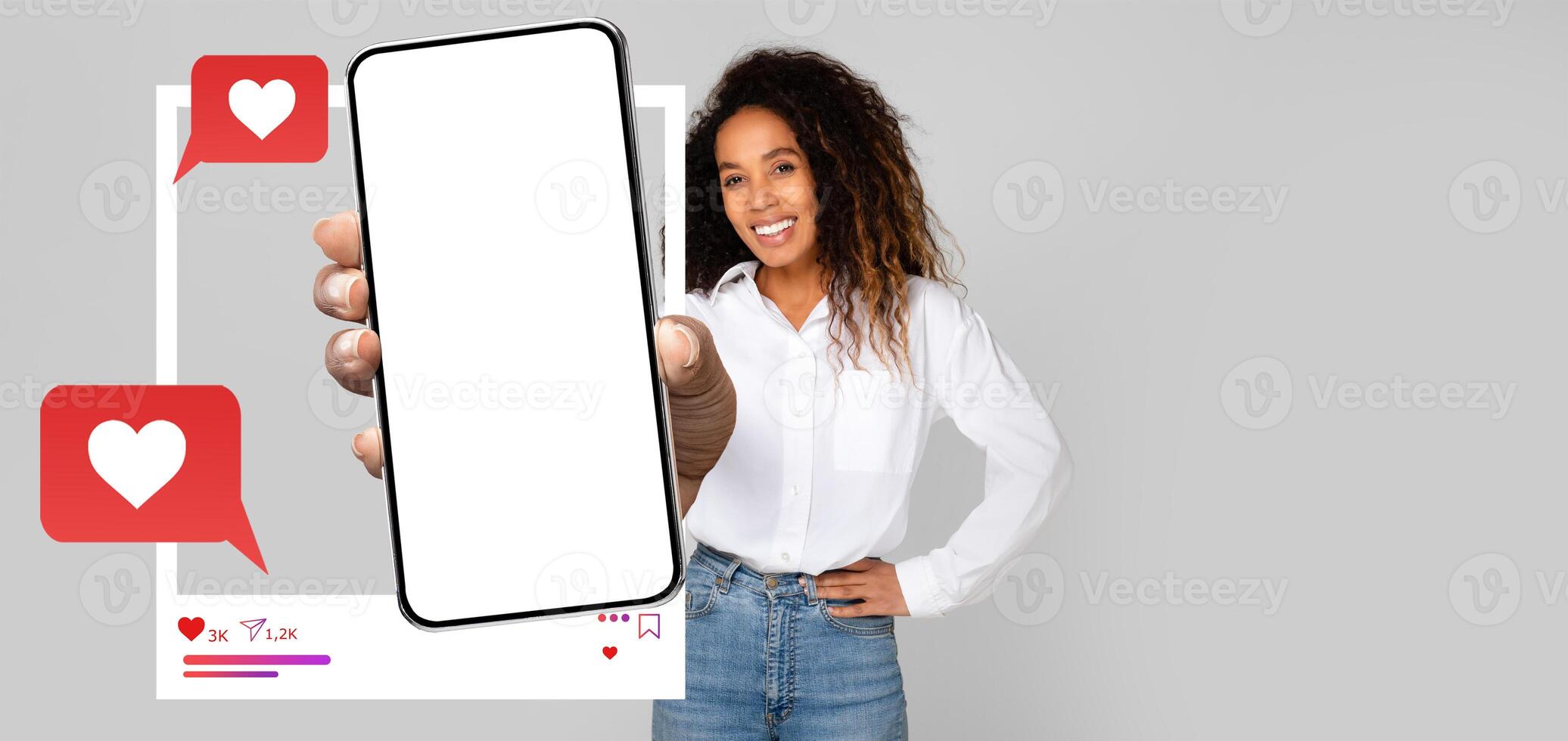 An influencer is showcasing a smartphone with a blank screen, surrounded by chat bubbles and heart icons. The backdrop is neutral, emphasizing the modern social media interaction. photo