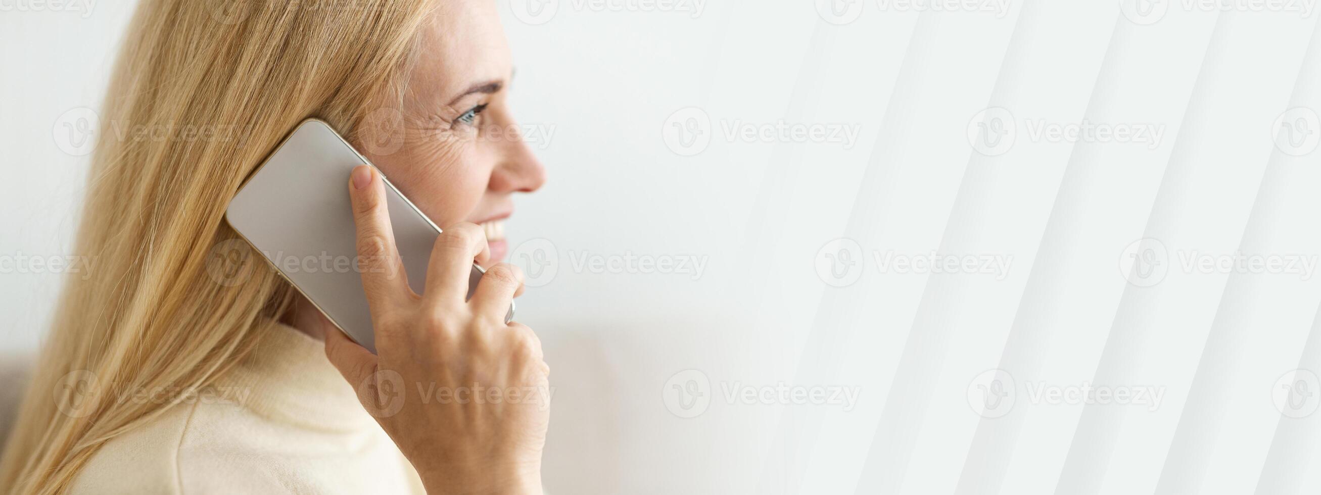 Mature Blond Woman Talking On Phone, Closeup, Side View, copy space photo