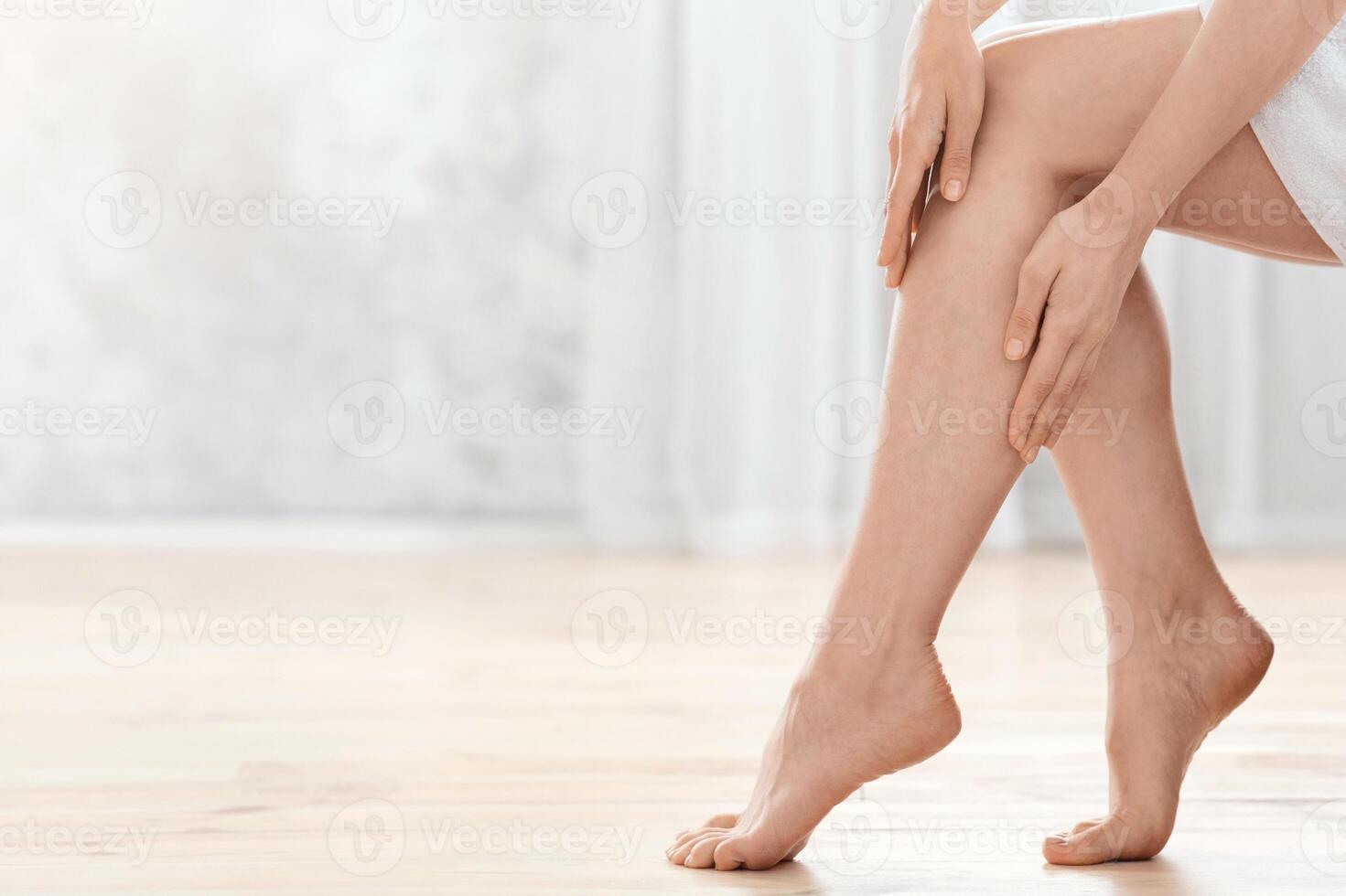 Skin care concept. Closeup of female legs, woman enjoying her silky skin, home interior, copy space photo