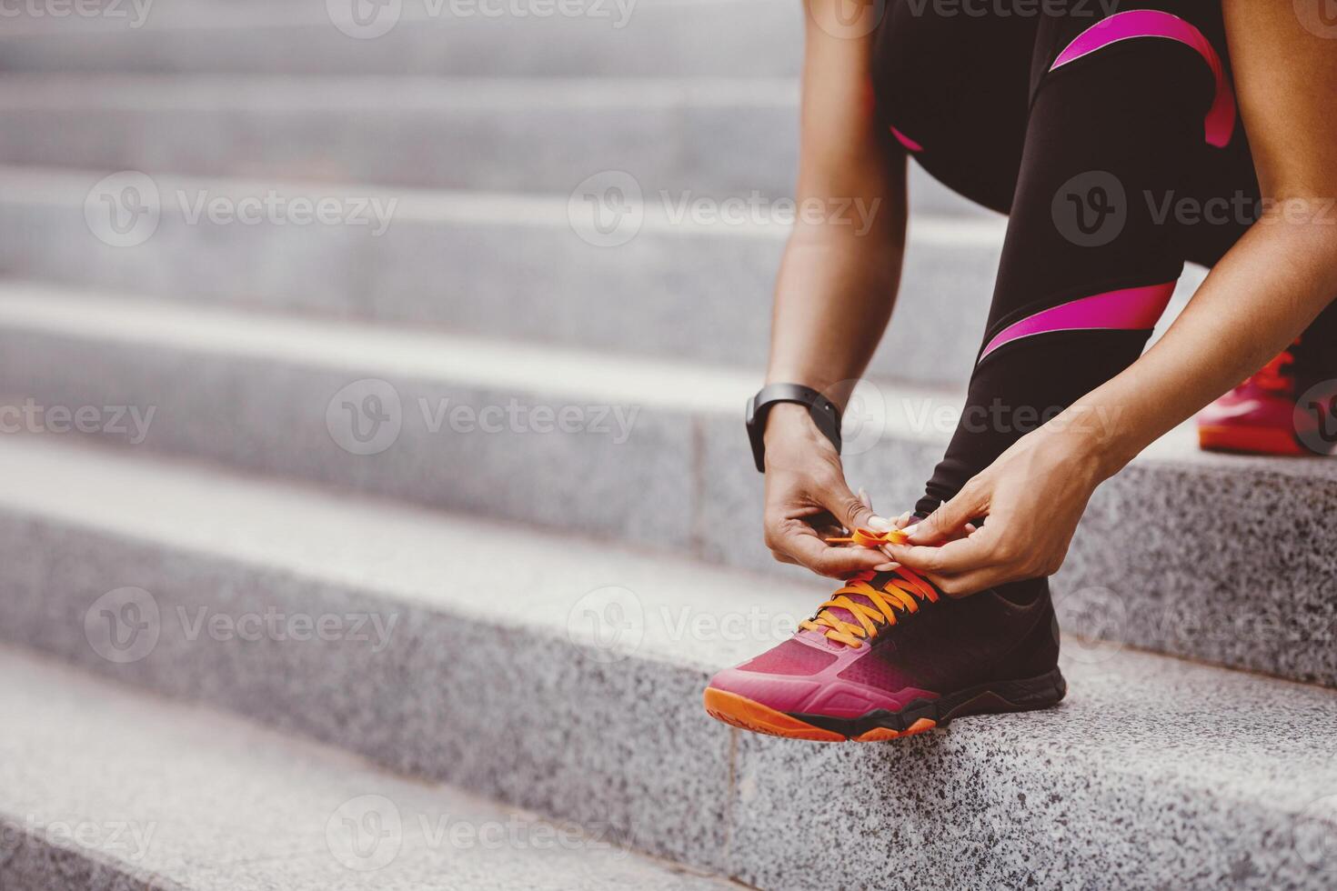 Start jogging on street. African american girl in sportswear tying shoelaces on sneakers on stairs, free space, cropped photo