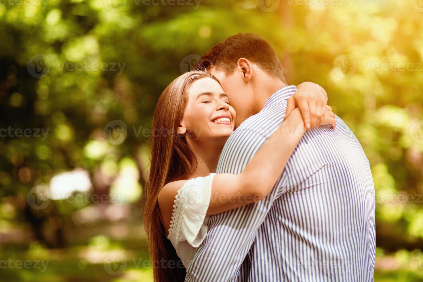 Tender couple embracing, bonding to each other at summer park on bright day. Blank space photo