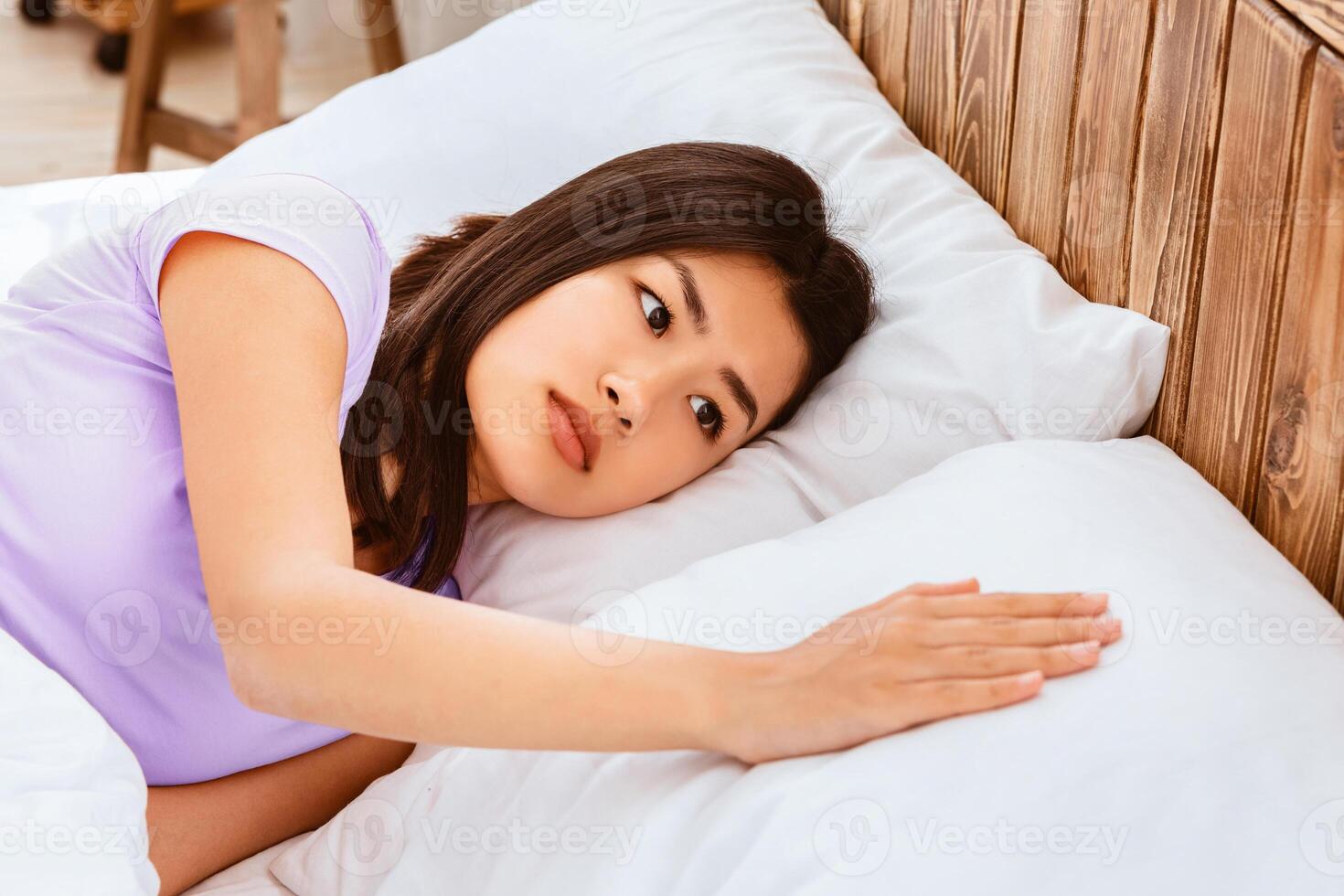 After-Divorce Depression. Sad Asian Girl Touching Pillow Suffering From Loneliness After Breakup Lying In Bed Alone At Home. Selective Focus photo