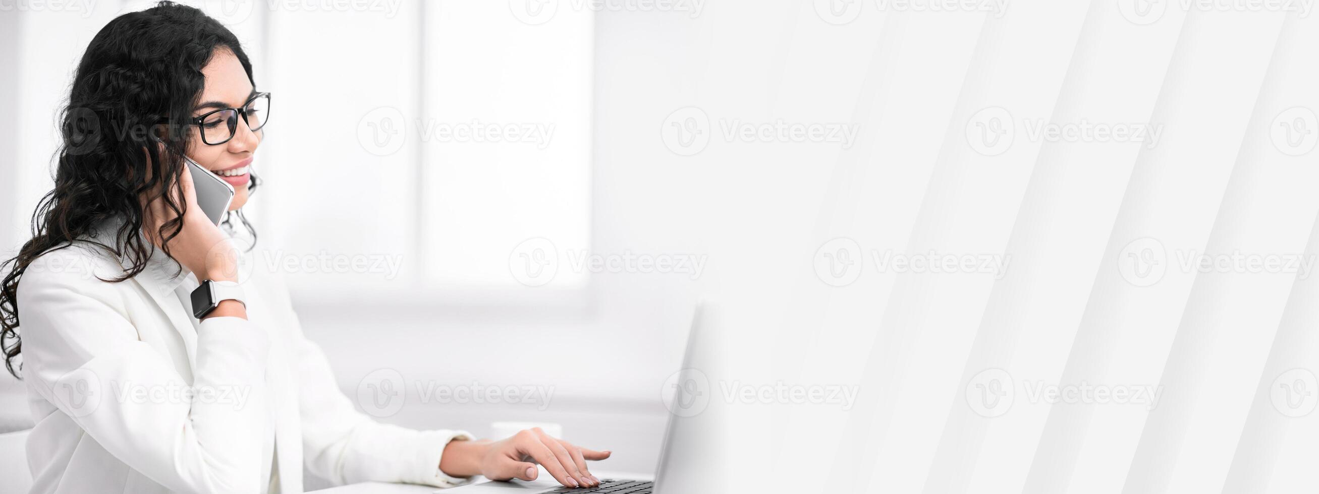 Business Call. Happy mexican woman talking on mobile phone, consulting client and using laptop. Copy space photo