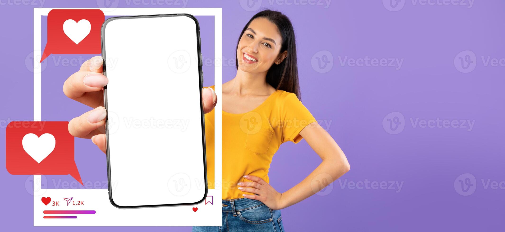 An influencer stands against a solid purple background, holding a smartphone with a blank screen. Chat bubbles and love icons indicate social media interaction and online messaging. photo