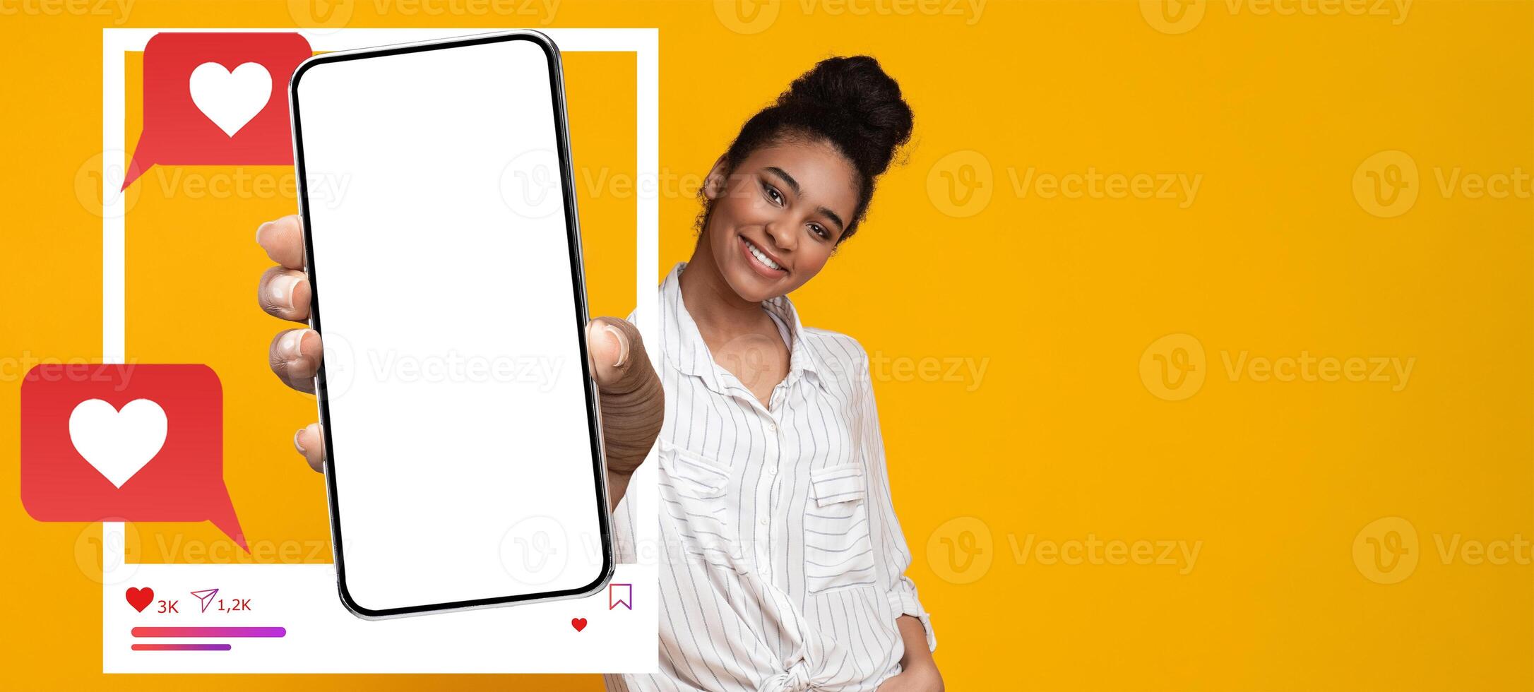 A confident influencer holds a blank smartphone against a vibrant yellow background. She interacts with her online audience, representing modern social media engagement and communication. photo