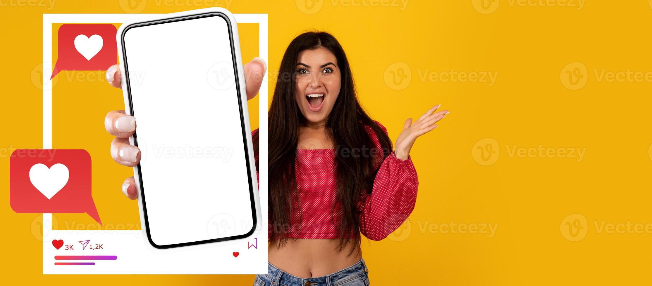An enthusiastic influencer excitedly holds a smartphone displaying a blank screen for a social media application. photo