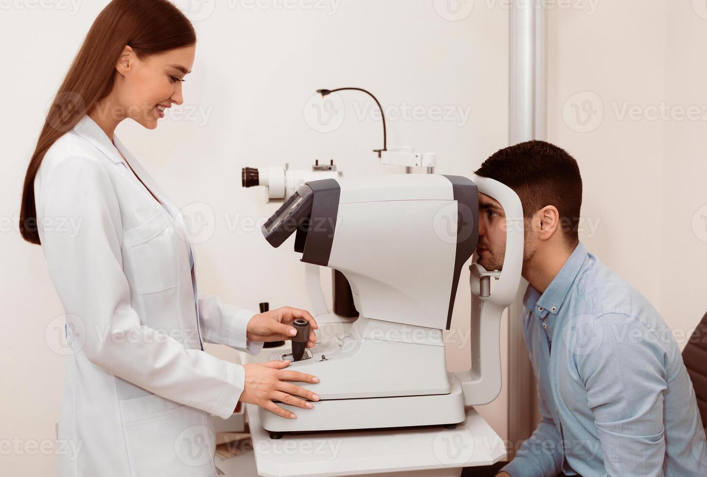 A young man undergoes an eye examination as a professional optometrist operates a testing machine, ensuring accurate assessment of vision health during a routine visit. photo